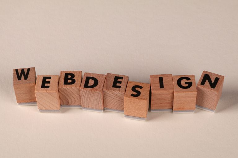 Une histoire de site Internet... Wooden blocks spelling 'web design' creatively showcase digital design concept.